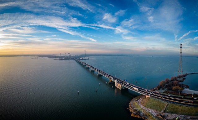 Birds eye view van de Haringvlietbrug in de provincie Zuid-Holland bij opgaande zon, met verkeer dat over de brug heen rijdt