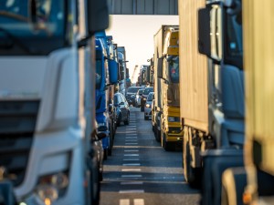 Twee rijen vrachtwagen en ander verkeer op de weg in het havengebied van Rotterdam